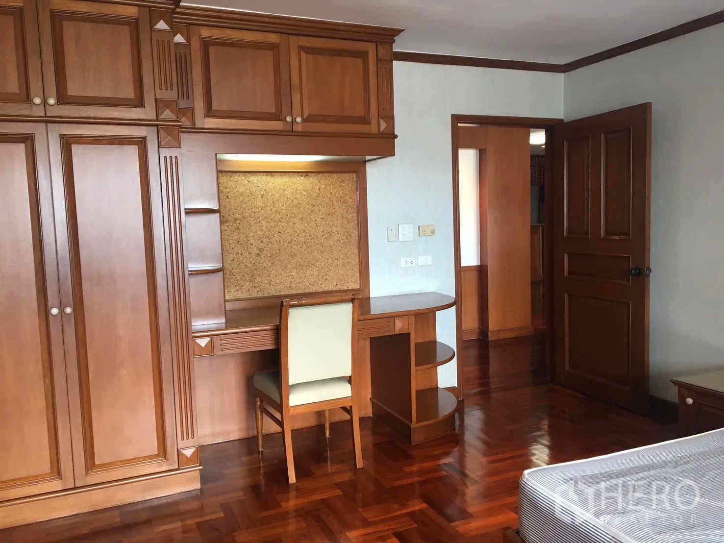 公寓 出租在Watthana, Bangkok - 卧室细节：整面衣柜与带书架的内置书桌。