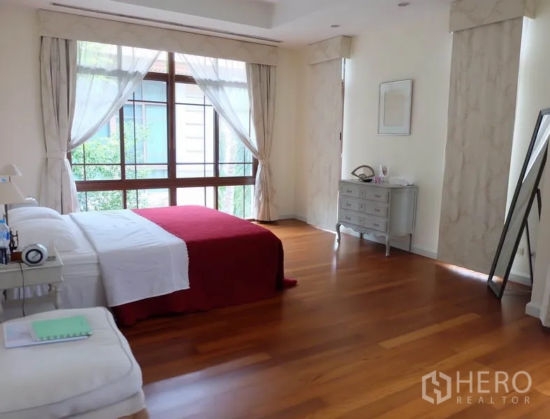บ้าน ให้เช่าในWatthana, Bangkok - ห้องนอนหลักโปร่งโล่ง พื้นไม้ หน้าต่างบานใหญ่ ผ้าม่านบาง และผ้าคลุมเตียงสีแดง