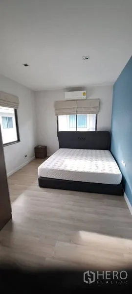 Detached House for rent in Lat Krabang, Bangkok - Guest bedroom with double bed, blue accent wall and abundant natural light