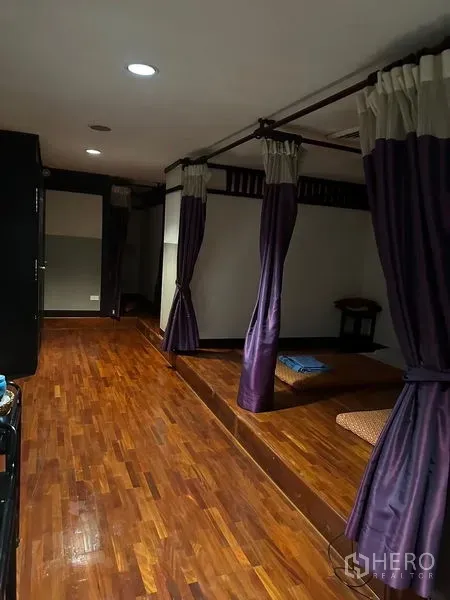 Shophouse for rent in Phra Khanong, Bangkok - Thai-style massage cubicles with purple curtains and polished wooden flooring.