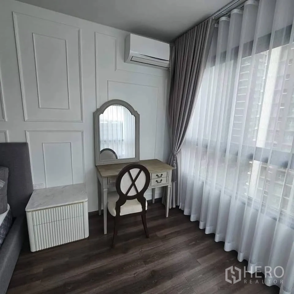 คอนโด for rent in Huai Khwang, Bangkok - โต๊ะเครื่องแป้งพร้อมเก้าอี้ข้างหน้าต่างสูงเต็มบานและผ้าม่านทึบโปร่ง