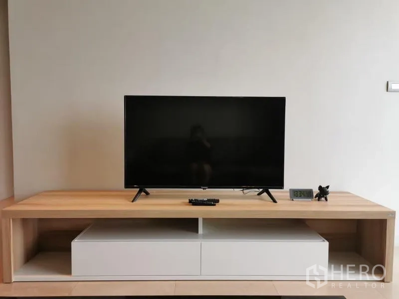 Condominium for rent in Pathum Wan, Bangkok - Flat-screen TV on wooden media console in a minimalist living room.