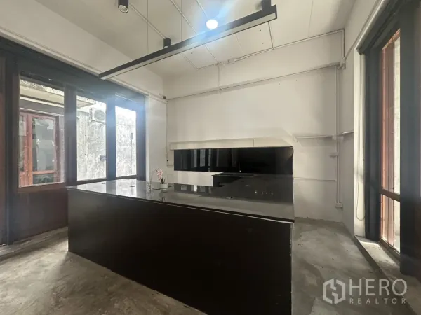 带办公室的家 出租在Pathum Wan, Bangkok - 开放式房间，长条黑色中岛台，适合咖啡或展厅使用。