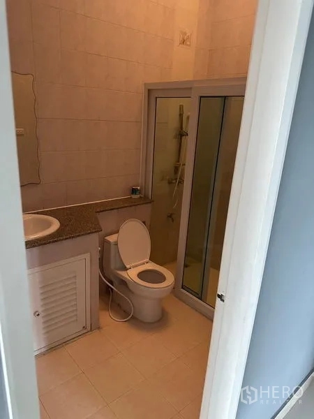 Townhouse for rent in Bang Kapi, Bangkok - Bathroom with glass shower enclosure, toilet and vanity.