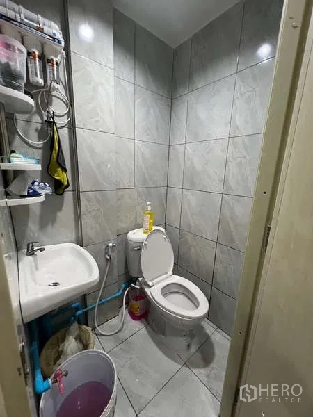 Retail Space for rent in Khlong Toei, Bangkok - Compact restroom with toilet, small sink and gray tiled walls.