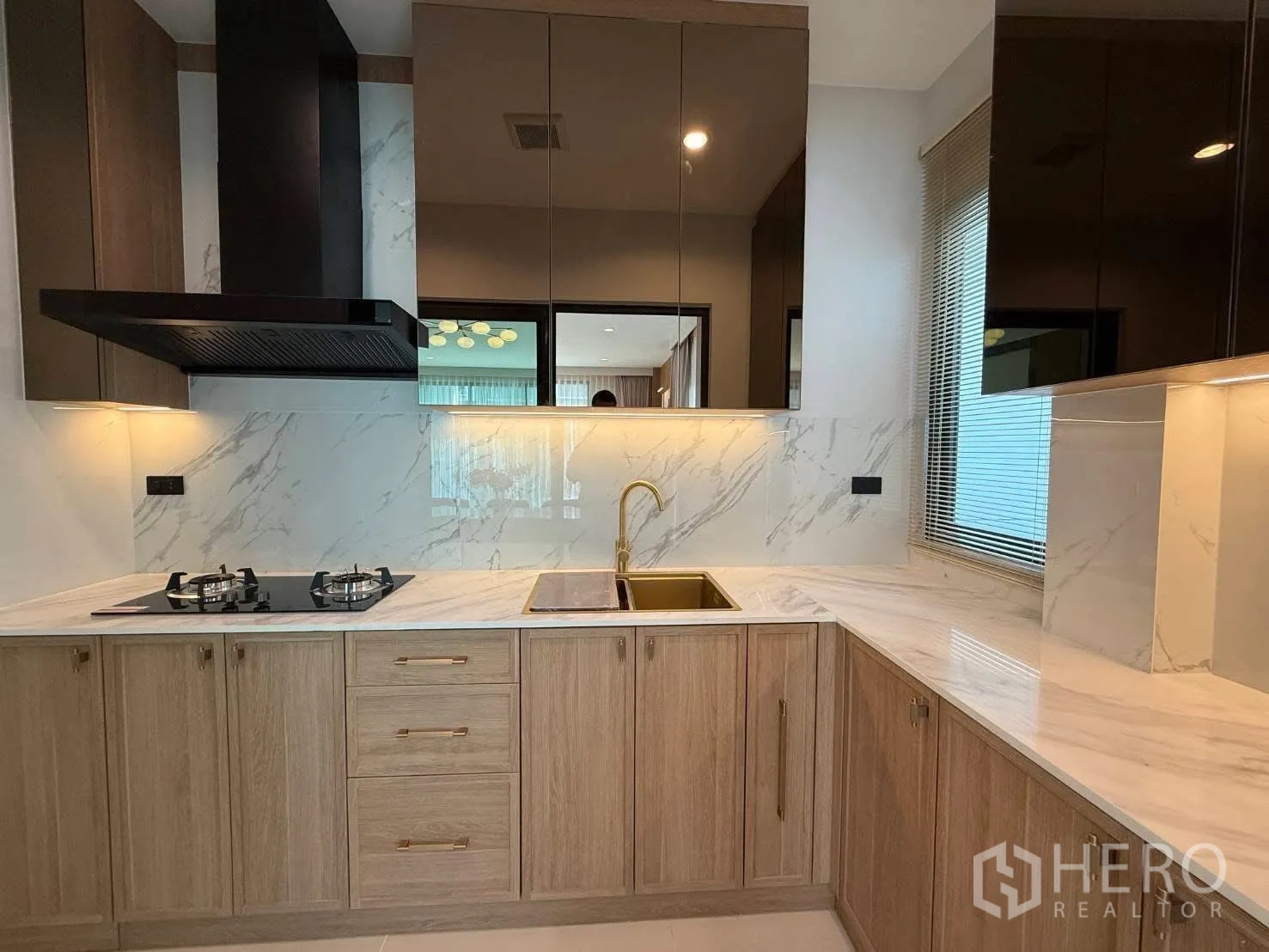 独栋房屋 for rent in Bang Phli, Samut Prakan - L形现代厨房，仿大理石墙面，燃气炉灶与金色水龙头木柜。