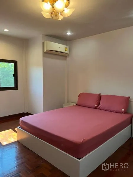 Detached House for rent in Samut Prakan - Cozy second bedroom with wood flooring, window light, and air conditioner.