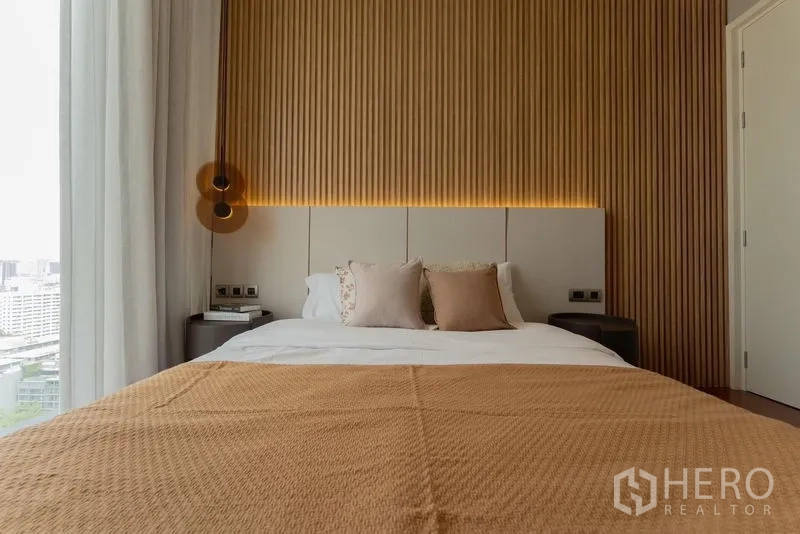 Condominium for rent in Watthana, Bangkok - Second bedroom front view with wooden feature wall, soft pillows and city outlook.