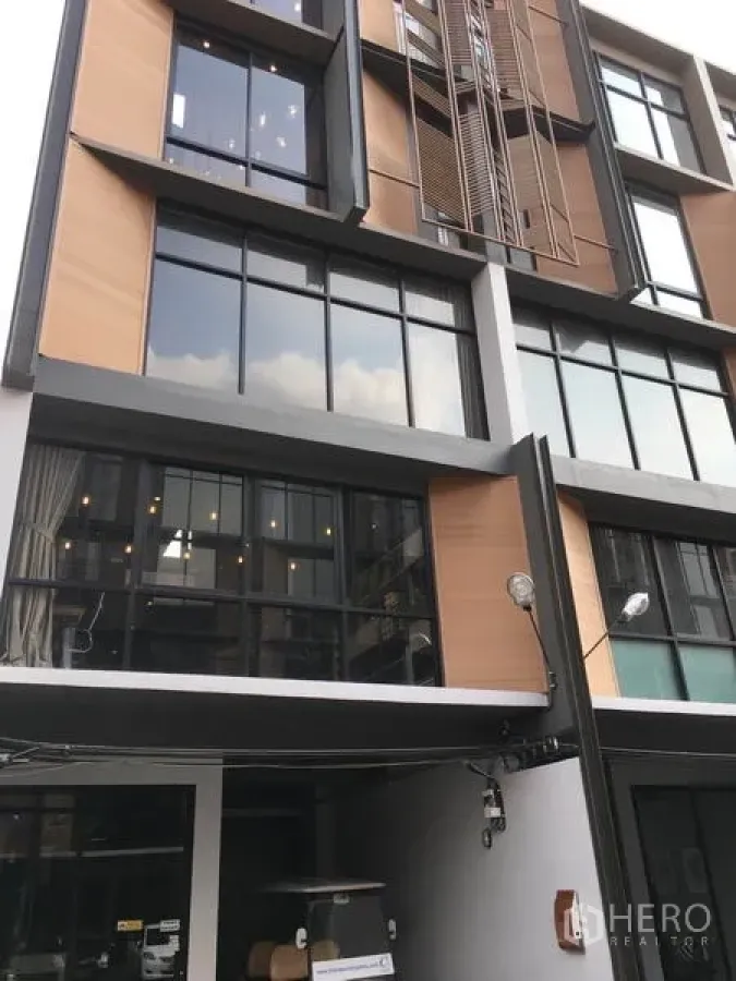 带办公室的家 出租或出售在Suan Luang, Bangkok - Suan Luang 区现代多层 Home Office 外立面，大窗与木质装饰板。