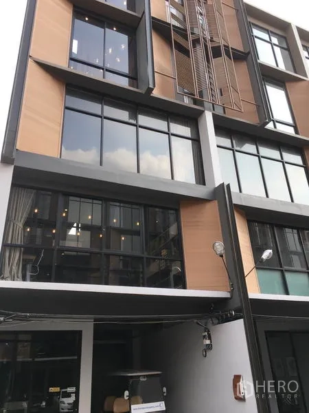 带办公室的家 出租或出售在Suan Luang, Bangkok - Suan Luang 区现代多层 Home Office 外立面，大窗与木质装饰板。