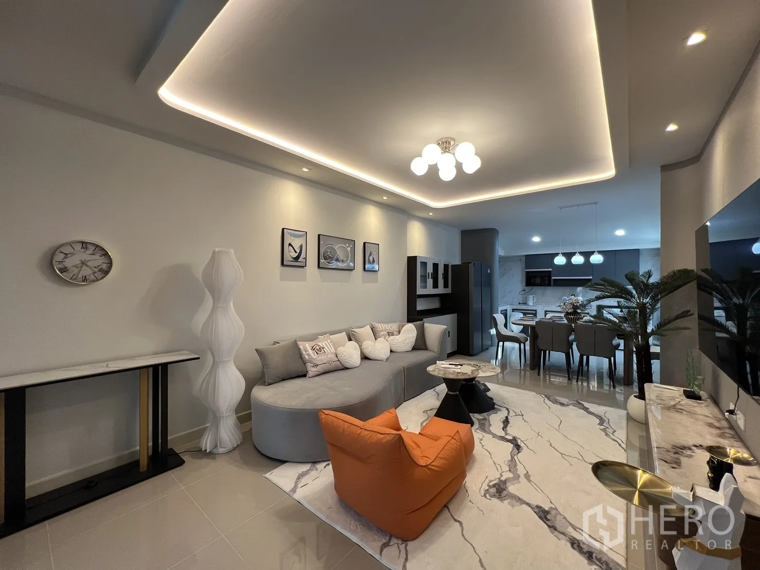 联排别墅 for rent in Bang Phli, Samut Prakan - 开阔客厅，弧形沙发、大理石纹地毯与厨房景观。
