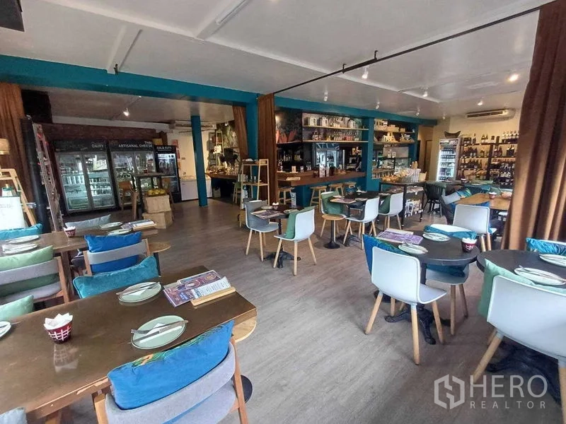 Retail Space for rent in Watthana, Bangkok - Dining area with mixed tables and chairs on wood-look flooring.