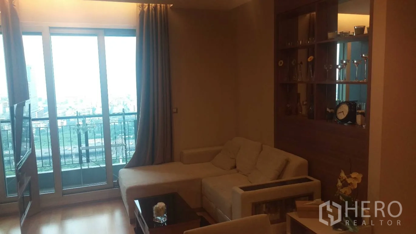 คอนโด ให้เช่าในRatchathewi, Bangkok - ห้องนั่งเล่นอบอุ่น โซฟาเข้ามุม ชั้นวางบิวท์อิน และประตูระเบียงมองเห็นวิวเมือง
