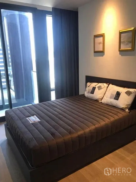 公寓 出租在Bang Rak, Bangkok - 次卧配双人床，通高玻璃门可通往阳台风格，灯光柔和。