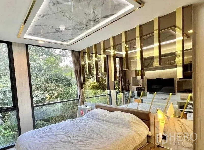 公寓 出售在Watthana, Bangkok - 卧室配落地窗与园景，石纹吊顶与金色装饰。