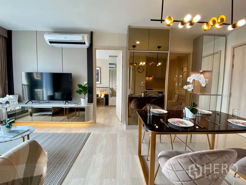 公寓 出租在Pathum Wan, Bangkok - 开放式客餐厅，镜面柜、电视柜与温润木地板。