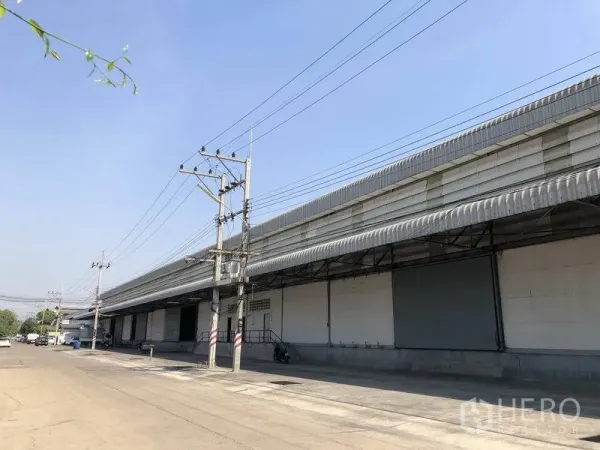 货栈 出租在Khlong Luang, Pathum Thani - 仓库外立面沿宽阔工业道路分布多组装卸口。