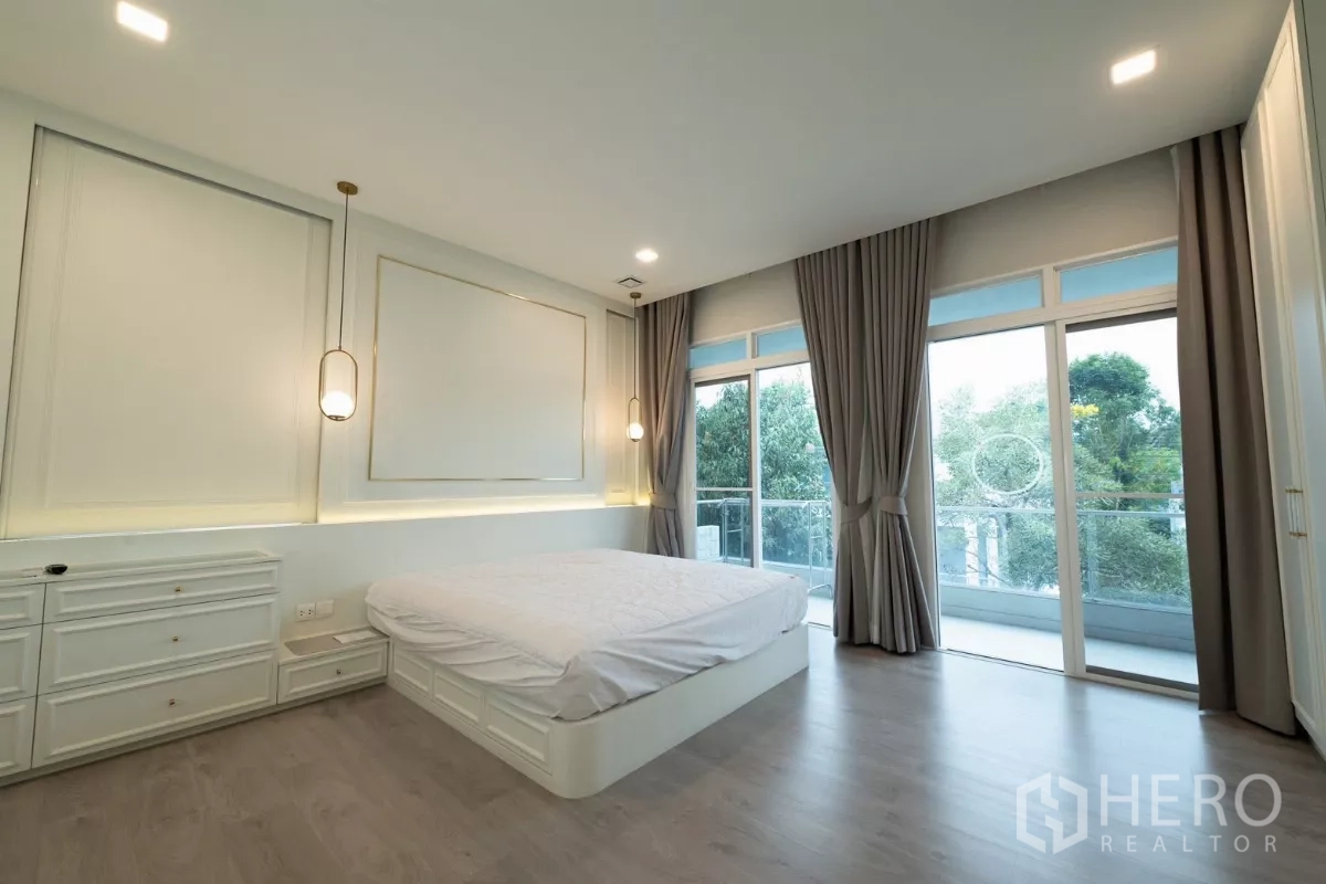 Detached House for rent or sale in Prawet, Bangkok - Spacious master bedroom with balcony access and full-height windows.