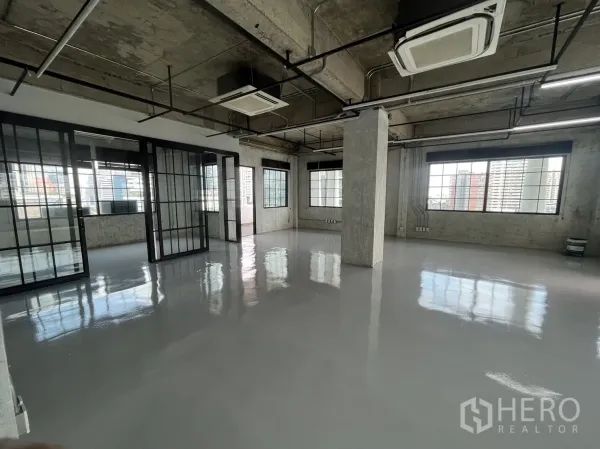 办公空间 出租在Khlong Toei, Bangkok - 开放式办公区，滑动玻璃隔断、外露管线、线性照明与大窗户。