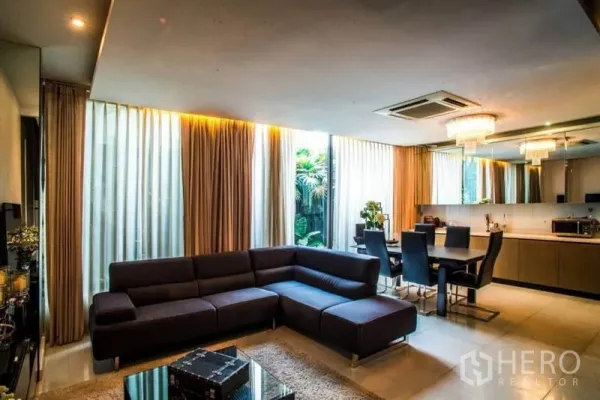 联排别墅 出租或出售在Watthana, Bangkok - 明亮的客餐厅一体区，转角沙发与餐桌，大窗帘
