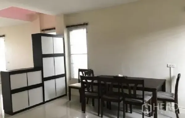 Home Office for rent in Lat Phrao, Bangkok - Dining area with six-seat table, glossy tile floor and cabinet partition by tall windows.