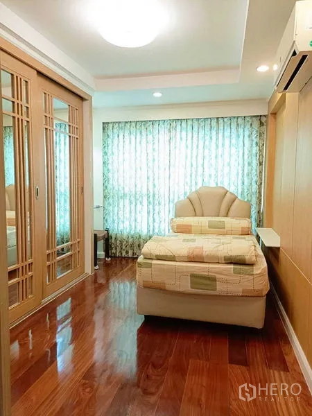 公寓 出租在Watthana, Bangkok - 温馨次卧，单人床，落地镜面推拉衣柜，窗帘与木地板。