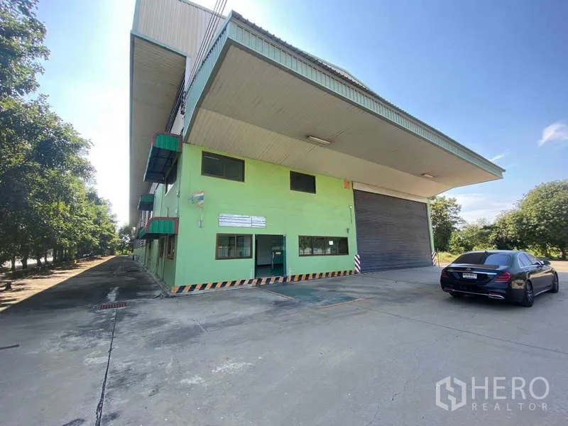 货栈 出租在Lat Lum Kaeo, Pathum Thani - 仓库入口近景，展示宽阔装卸区、办公窗户和大型卷帘门。