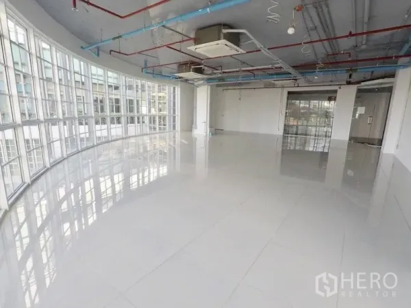 Retail Space for rent in Khlong Toei, Bangkok - Daylit showroom-style interior featuring wraparound windows, tiled floors, and ducted air-conditioning.