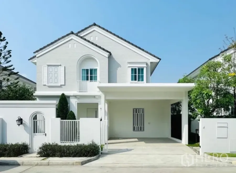 บ้าน ให้เช่าในBang Phli, Samut Prakan - มุมมองด้านหน้าบ้านเดี่ยวสองชั้นสีขาวสไตล์โมเดิร์น พร้อมโรงจอดรถและประตูรั้ว