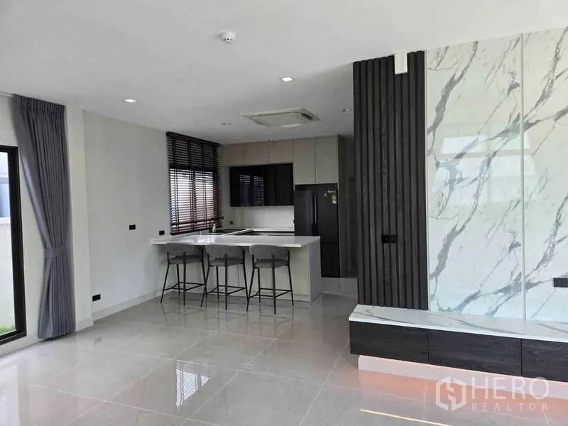 Detached House for rent in Bang Phli, Samut Prakan - Open-plan living area with marble feature wall and kitchen island.