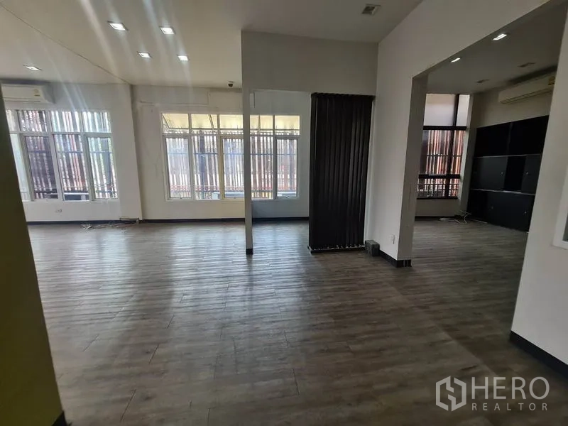 Retail Space for rent in Watthana, Bangkok - Open trading floor with wide windows, shelving, and a black screen divider.
