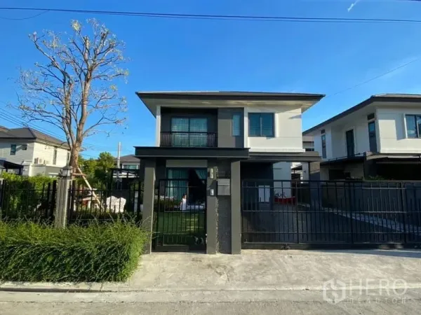 独立式住宅 出租在Bang Phli, Samut Prakan - 黑色金属围栏后的两层独栋住宅正立面。