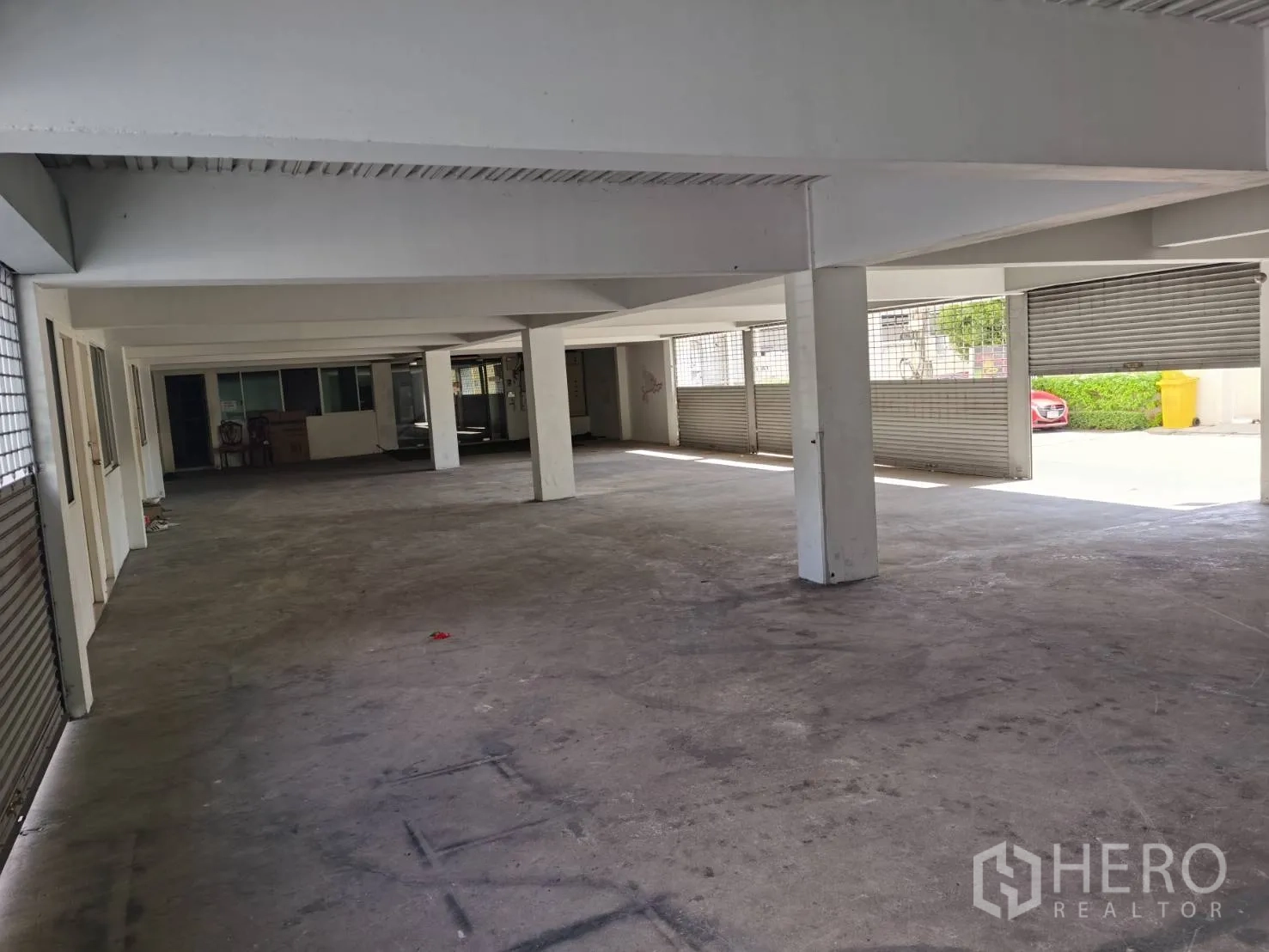 带办公室的家 出租或出售在Huai Khwang, Bangkok - 底层室内停车区，混凝土地面与卷闸门