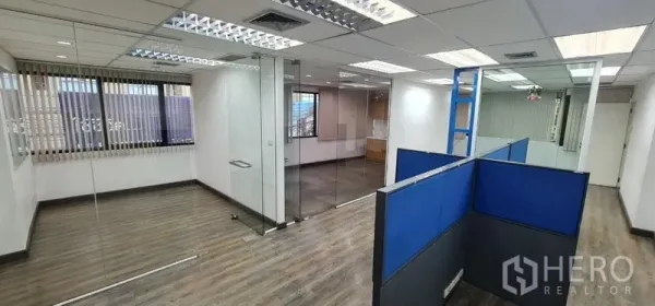 办公空间 出租在Watthana, Bangkok - 采光充足的开放式办公室，玻璃隔断、蓝色工位与木纹地板。