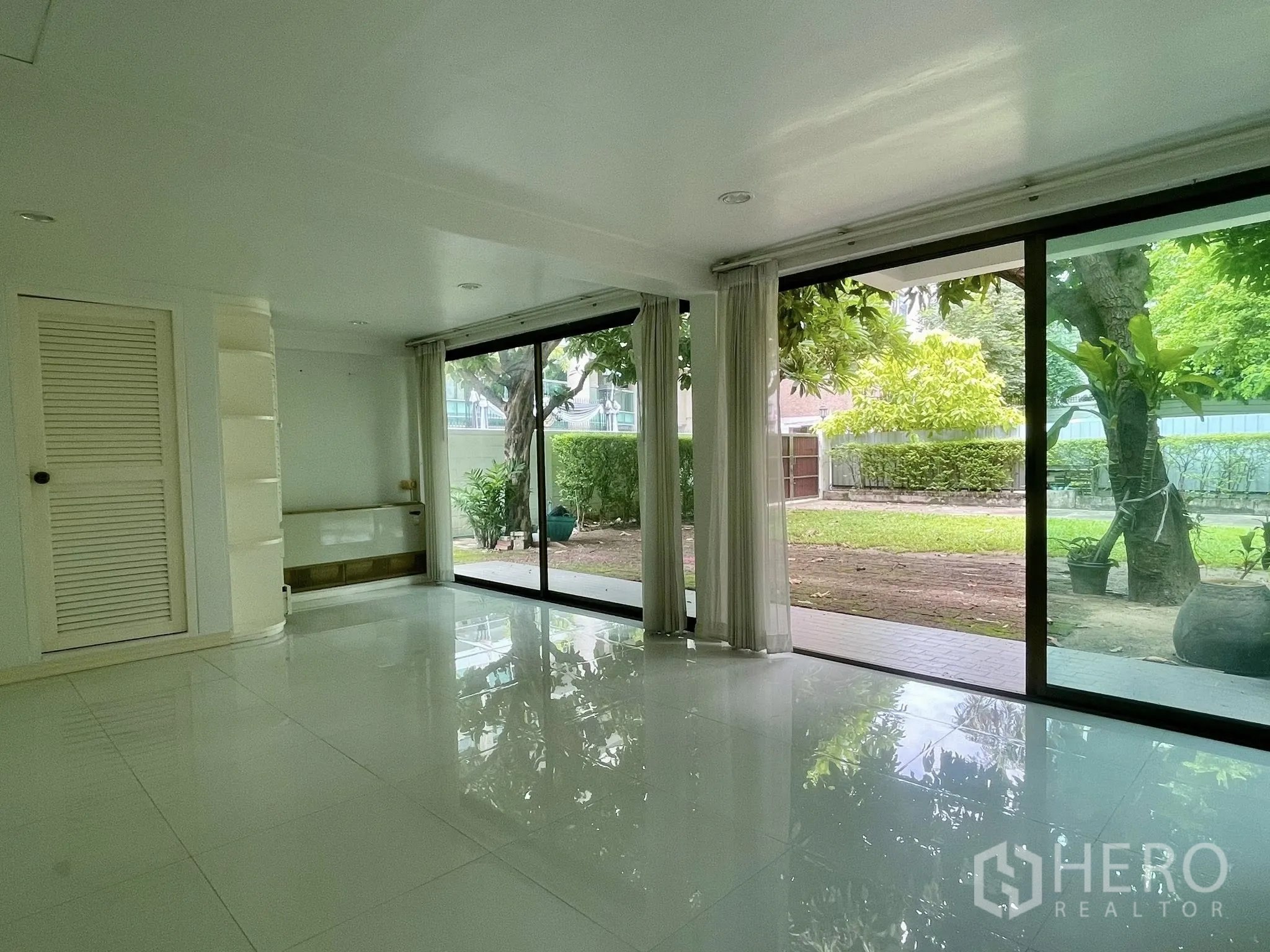 Detached House for rent in Pathum Wan, Bangkok - Bright white room with sliding glass doors opening to the garden.