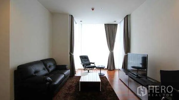 Condominium for rent - Cozy lounge with leather sofa, TV and full‑height curtains in a high‑rise condo.