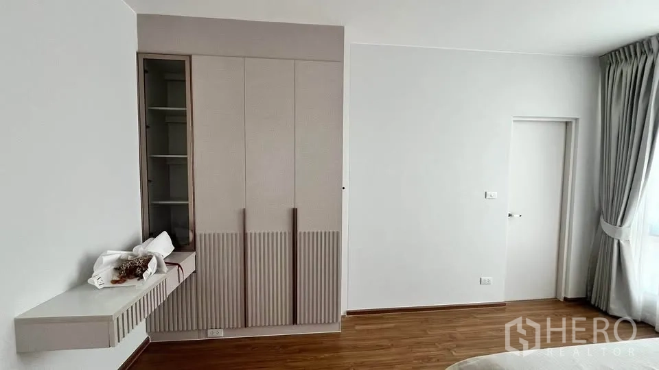 Townhouse for rent or sale in Bang Phli, Samut Prakan - Bedroom wall with built‑in wardrobe, shelving and wood flooring.
