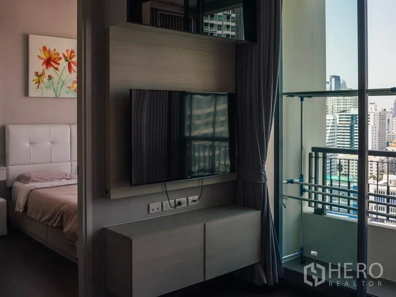 公寓 出租在Ratchathewi, Bangkok - 客厅电视墙，旁为推拉落地门通向阳台，可观城市景观。
