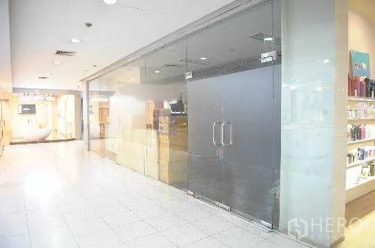 办公空间 出租在Khlong Toei, Bangkok - 室内走廊旁的玻璃门面办公单元，双开门与明亮地砖。