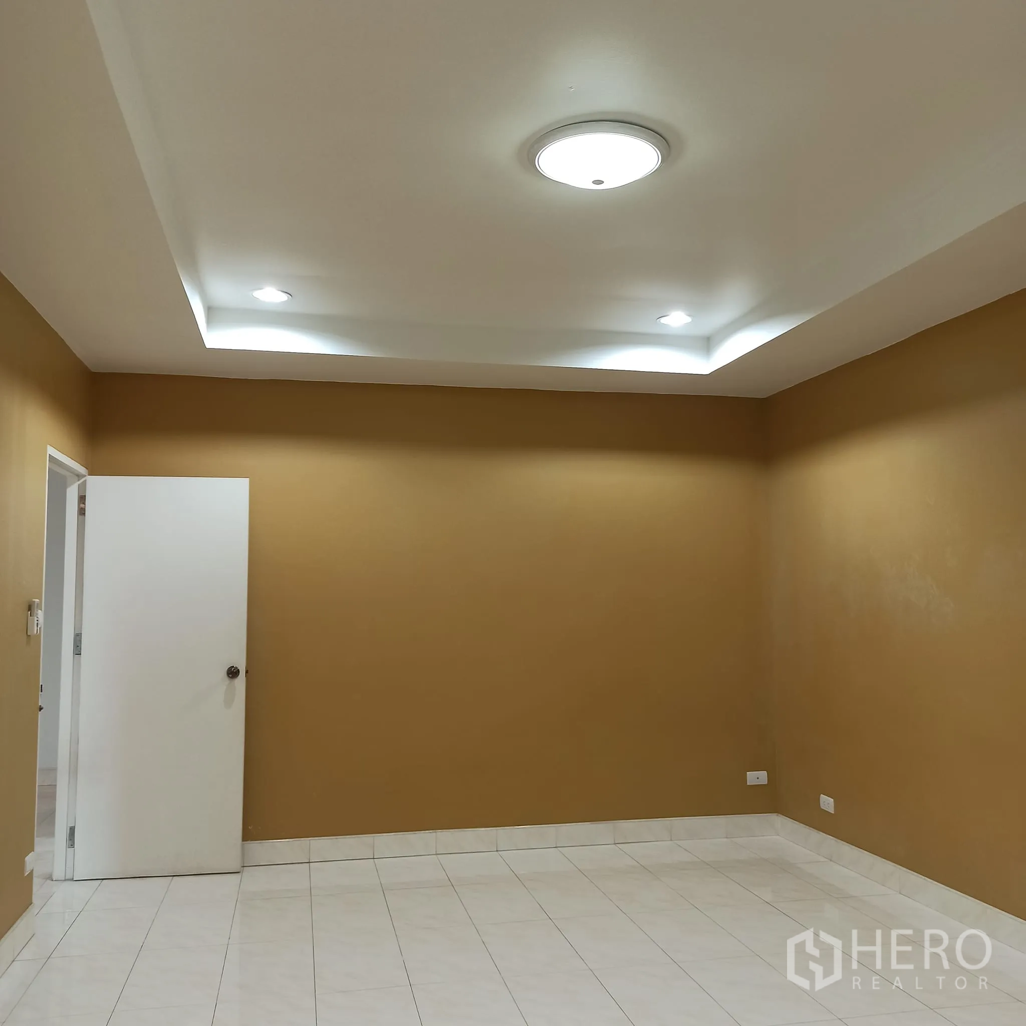 Townhouse for rent in Wang Thonglang, Bangkok - Large room with warm-toned walls and recessed ceiling lights.