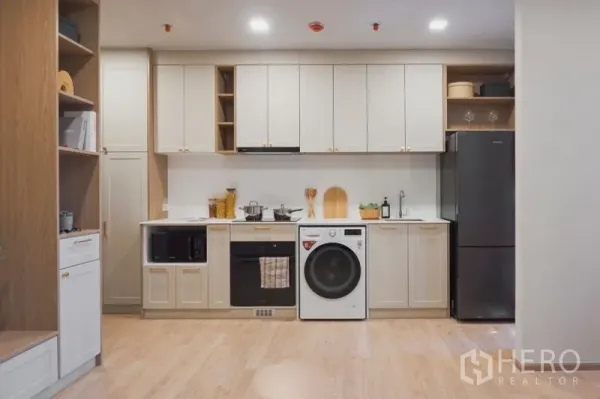 คอนโด ขายในSuan Luang, Bangkok - ครัวบิวท์อินเต็มผนัง มีเตาอบ ไมโครเวฟ เครื่องซักผ้า และตู้เย็น พื้นไม้โทนอ่อน