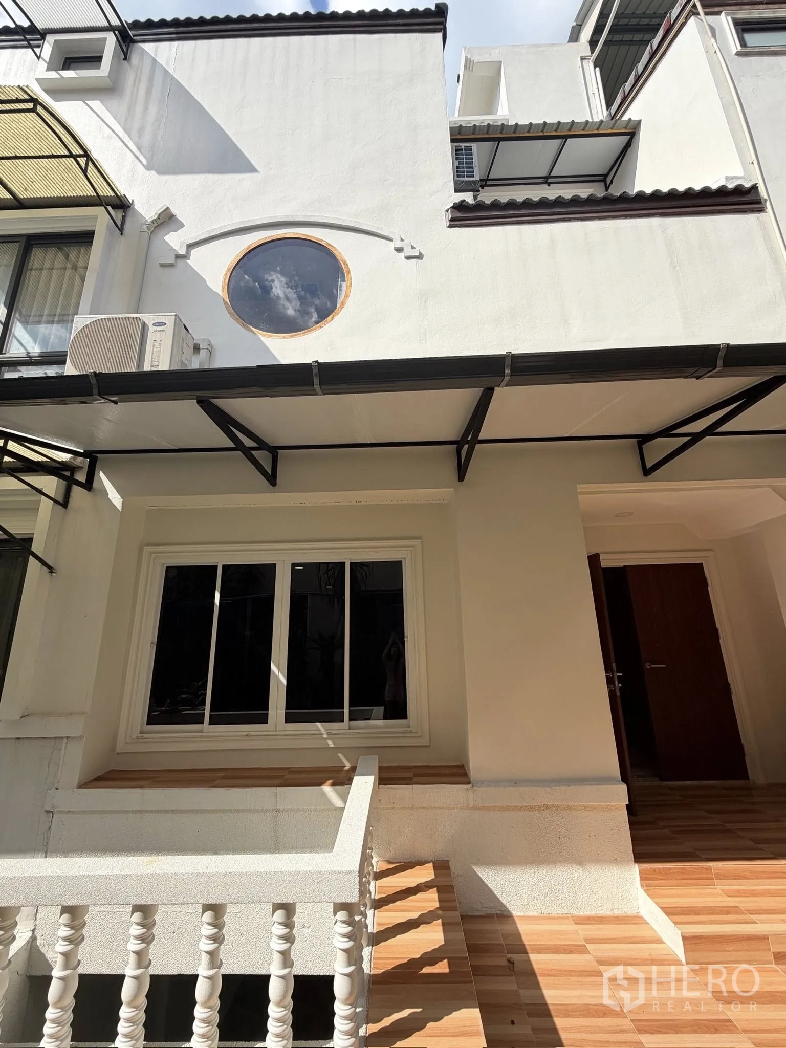 Townhouse for rent or sale in Yan Nawa, Bangkok - Front exterior with round feature window and small porch.