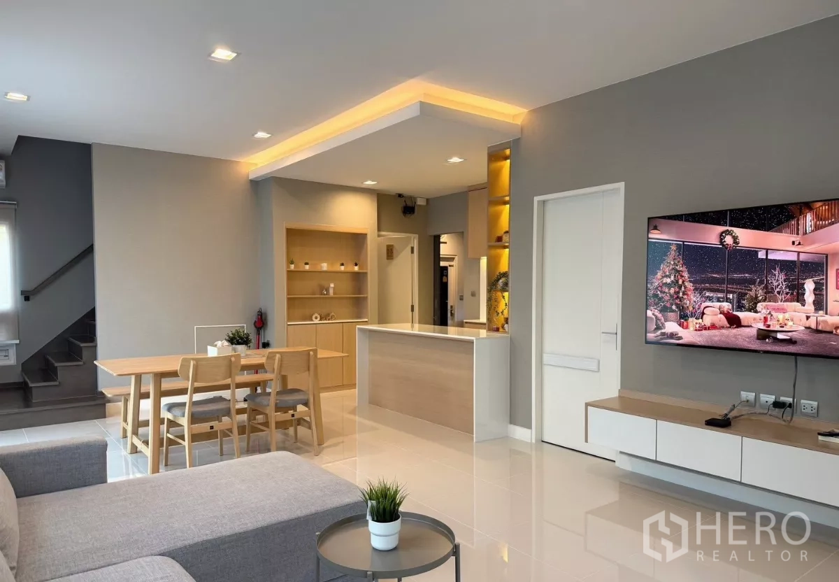 独立式住宅 出租在Prawet, Bangkok - 开放式客餐厅与厨房岛台，墙挂电视