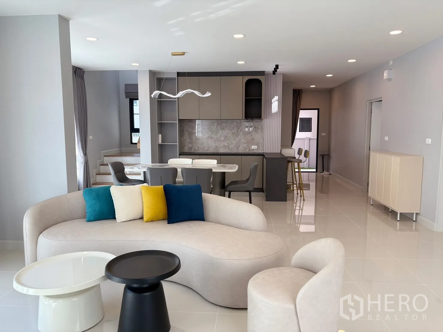 บ้าน for rent in Bang Phli, Samut Prakan - พื้นที่นั่งเล่น รับประทานอาหาร และแพนทรีแบบโอเพ่นแพลนพร้อมไฟสมัยใหม่ โทนสีอบอุ่น.