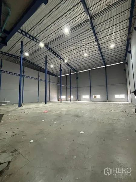 Warehouse for rent in Krathum Baen, Samut Sakhon - Spacious high-bay warehouse interior with steel columns, insulated roof and bright LED lights.