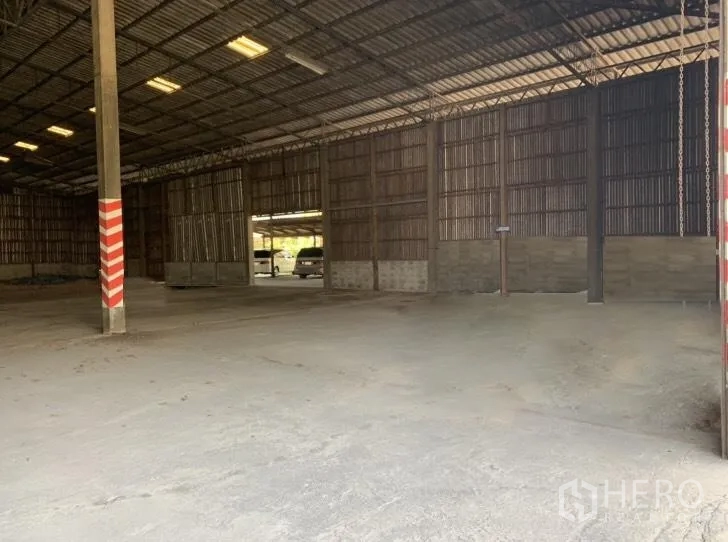 Warehouse for rent in Mueang Nakhon Pathom, Nakhon Pathom - Open‑plan interior facing wide sliding doors with truck access outside.