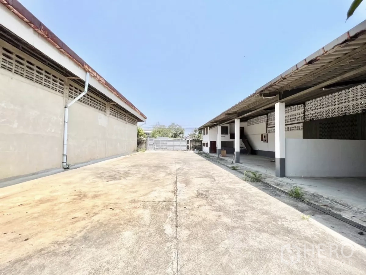 Warehouse for rent in Mueang Samut Prakan, Samut Prakan - Wide concrete yard between buildings providing ample truck turning space to front gate.