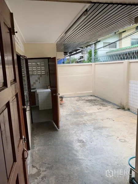 Townhouse for rent in Watthana, Bangkok - Back service yard with concrete floor and high privacy wall beside the kitchen.