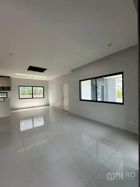 Detached House for sale in Lam Luk Ka, Pathum Thani - Bright open-plan living room with large windows and glossy tiled floor.