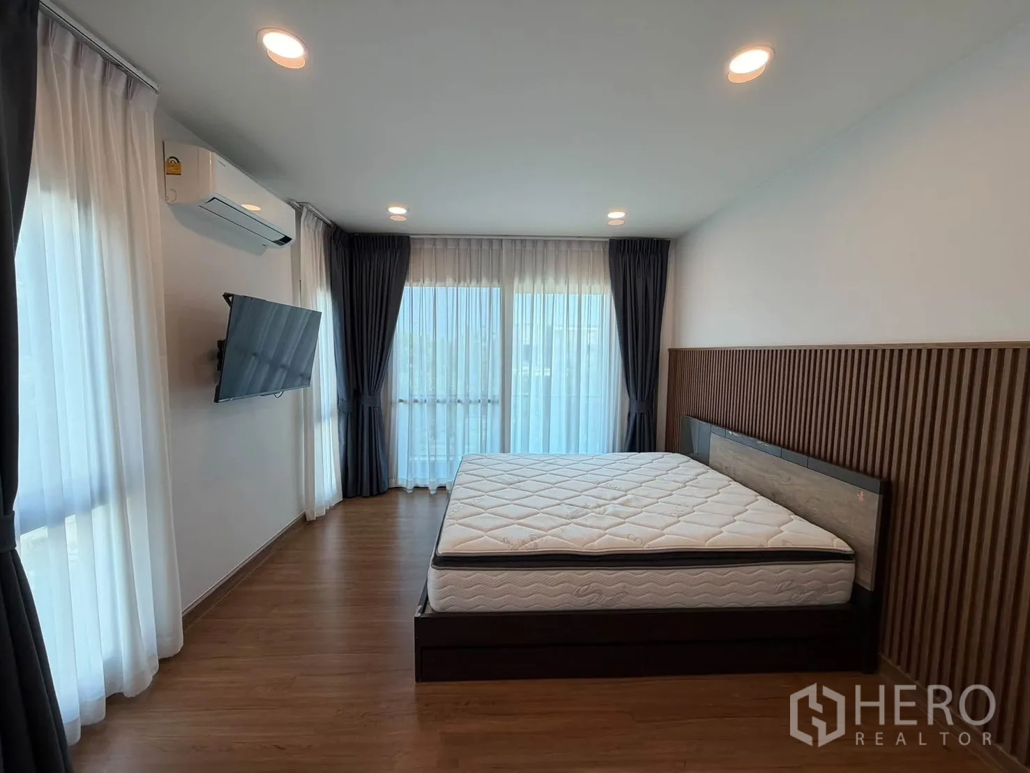 独栋房屋 for rent in Bang Phli, Samut Prakan - 主卧角度，墙挂电视与转角大窗。